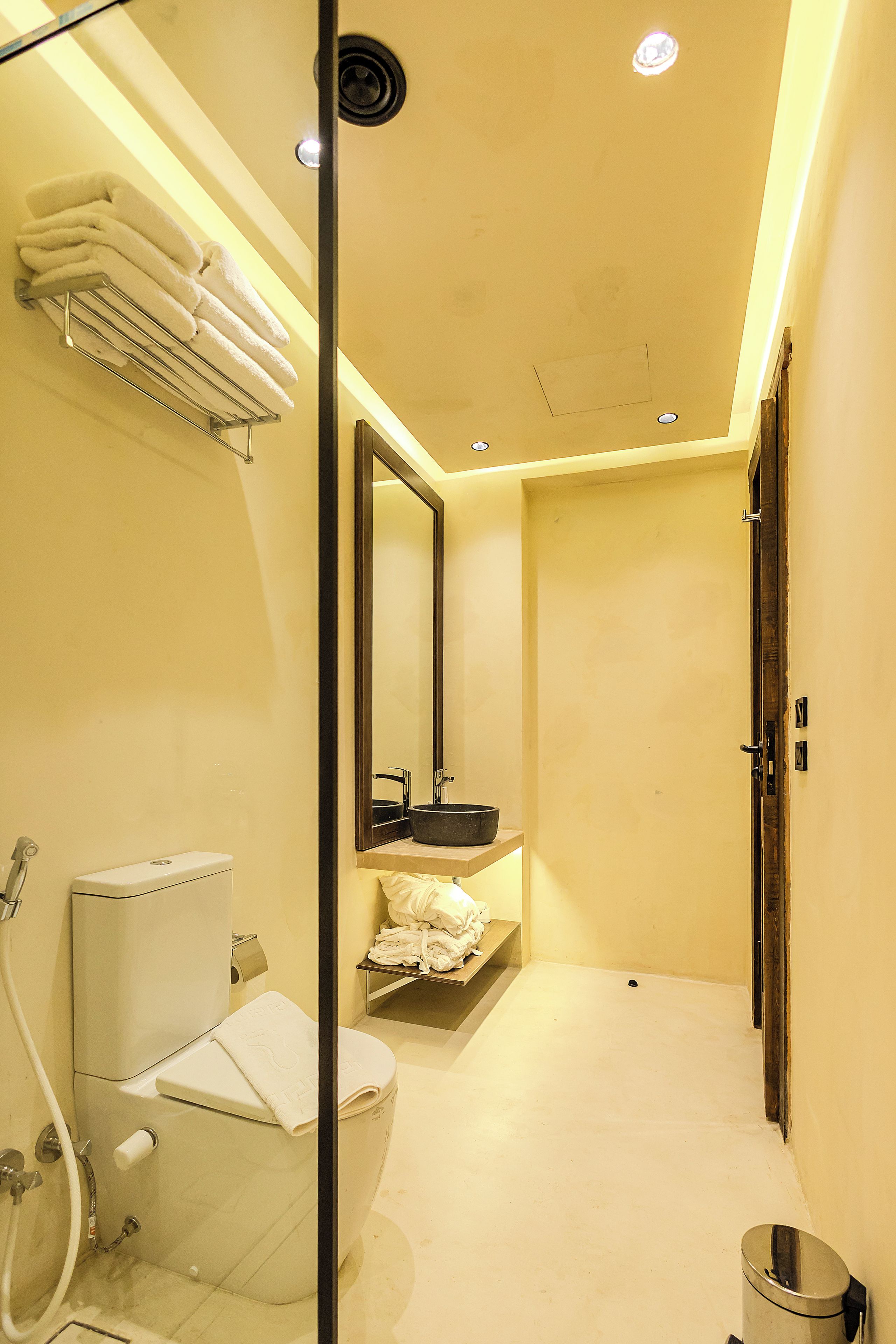 Un baño con inodoro, lavamanos y espejo.