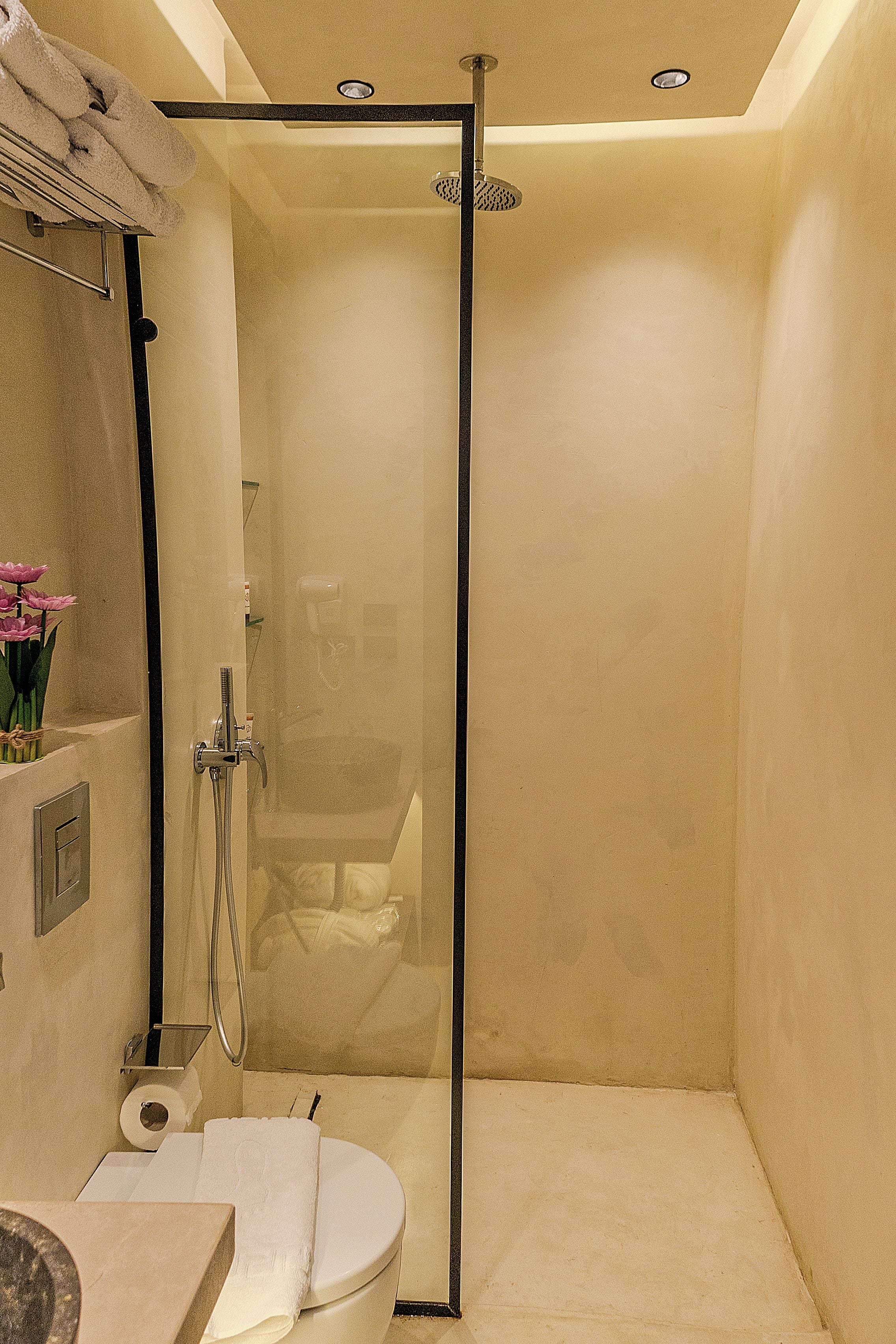 Une salle de bain moderne avec une douche à parois de verre, des toilettes et un lavabo.