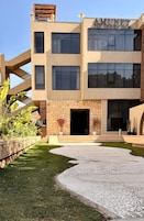 A modern building with a stone facade, large windows, and a clear entrance.