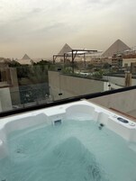 A hot tub with a view of pyramids in the background.