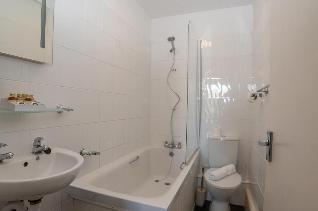 A bathroom with a bathtub, a sink, and a toilet.