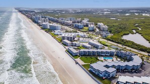 Un hôtel situé sur la côte, composé de plusieurs bâtiments, avec une plage et un port de plaisance.