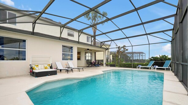 Ein überdachter Pool mit Liegestühlen und einer Terrasse.