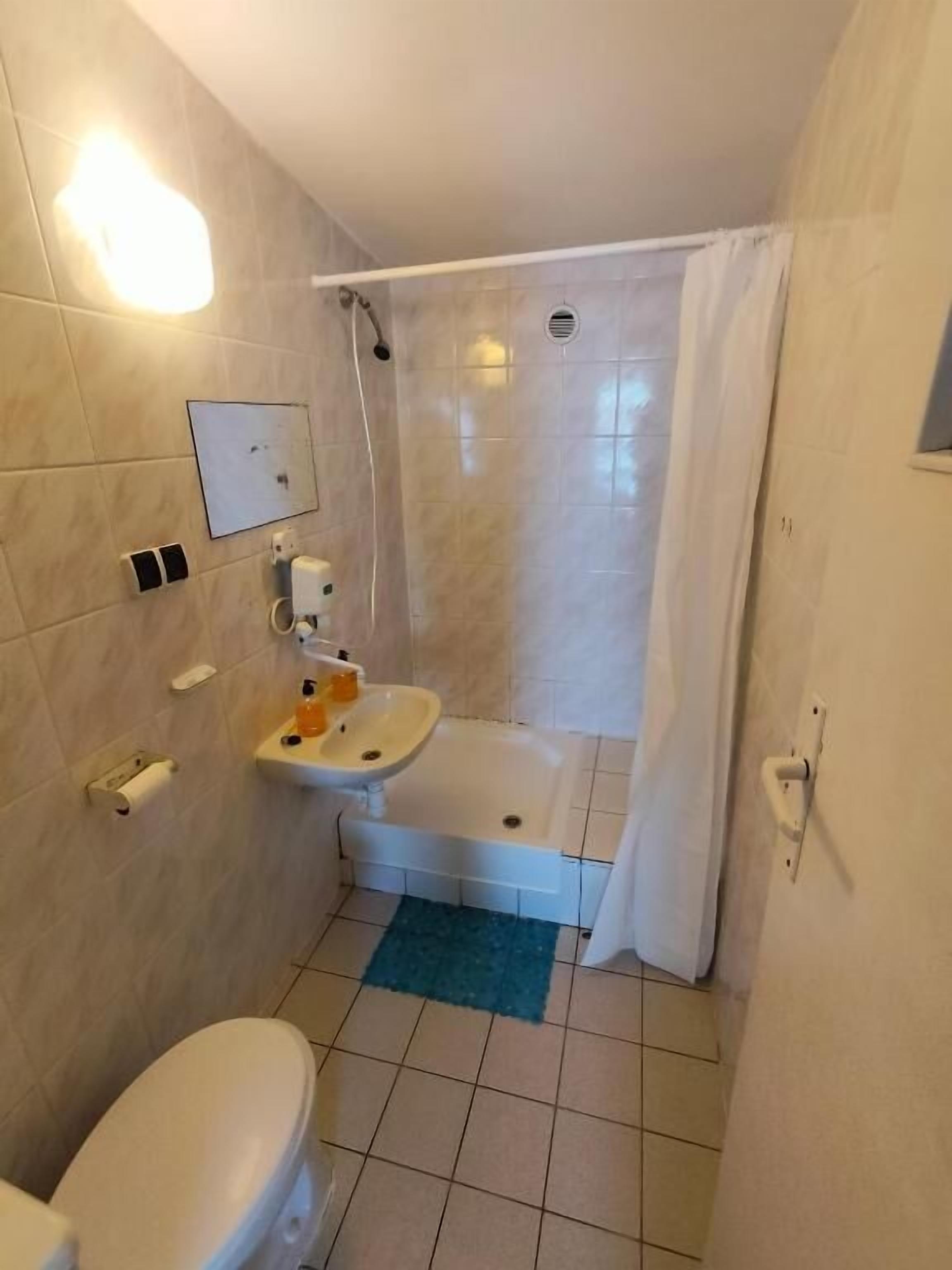 A bathroom with a toilet, sink, and shower.
