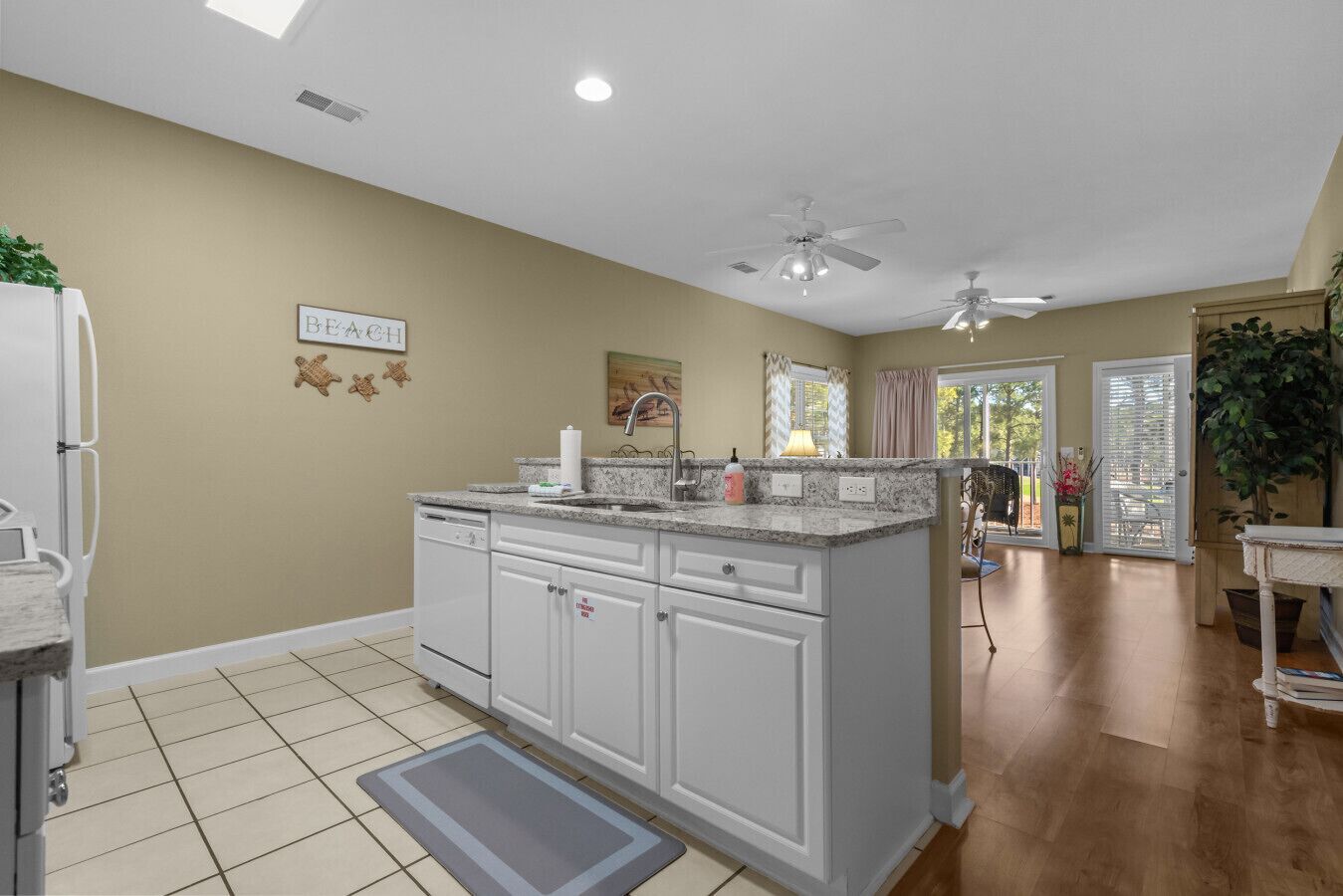 A kitchen with white cabinets, a granite countertop, and a ceiling fan.