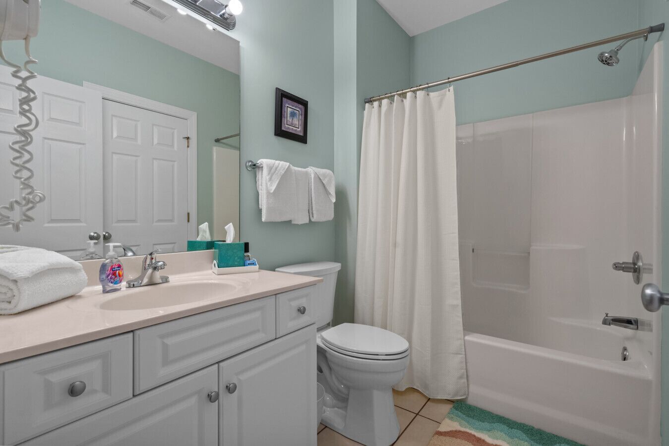 Un baño con lavamanos, inodoro y ducha.