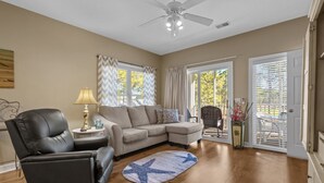 A living room with a sectional sofa, a leather chair, a lamp, and a star-patterned rug. - Stunning Sunset Beach Getaway (Sunset Beach)