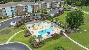 A hotel with a swimming pool, outdoor seating, and a parking lot. - Stunning Sunset Beach Getaway (Sunset Beach)
