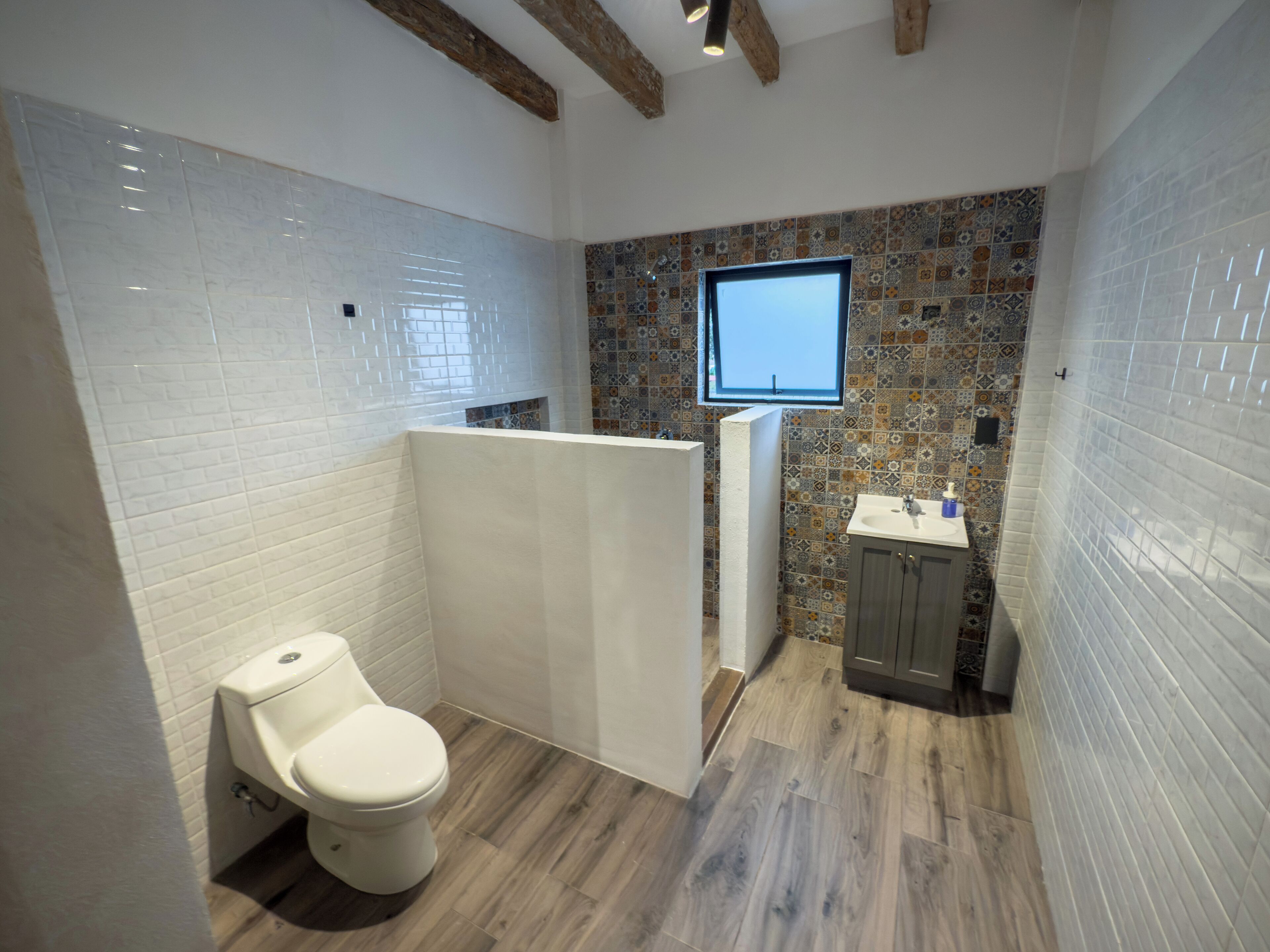 A modern bathroom with a toilet, shower, and sink.