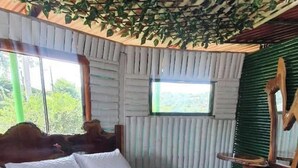 A bedroom with a bed, pillows, and a towel arrangement. - Eco Hotel Green Eden  (Pereira)