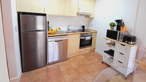 A compact kitchen with a stainless steel refrigerator, a dishwasher, a stove, and a microwave. - LA TERRAZA DE ESCARRILLA, with swimming pool in summer. Skiing 15min Formigal and Panticosa (Escarrilla)