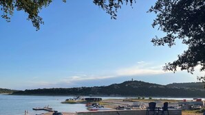 Un patio sul lago con posti a sedere all'aperto e vista sull'acqua.