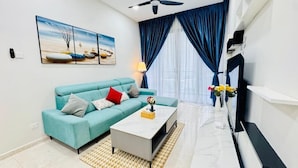 A modern living room with a teal sofa, a white coffee table, and a painting on the wall. - The Manor by Panorama Suite (Kuala Lumpur)