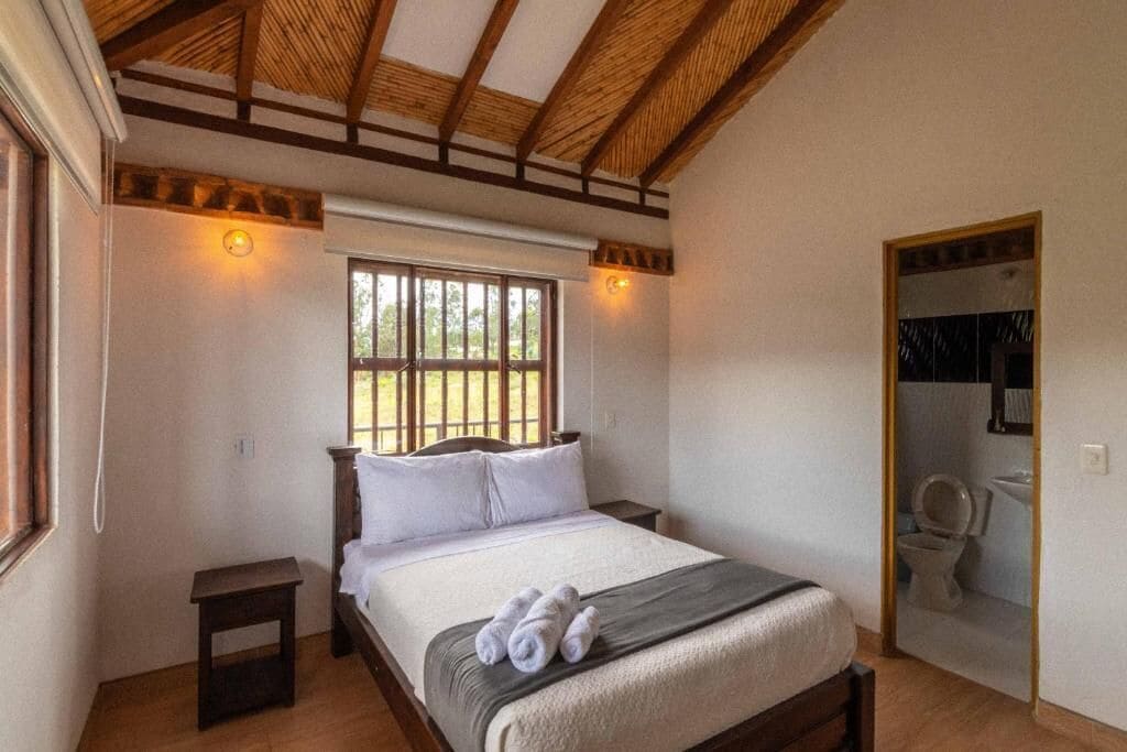 A bedroom with a bed, bedside table, and a window.
