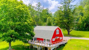 A red barn with a deck, surrounded by green grass and trees. - Barn-Again. Private Lake, Mtn view, fishing (Big Indian)