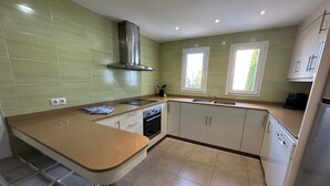 A modern kitchen with a central island, double sink, and built-in oven. - VILLA BLANCA, large villa ideal for families in Cala Dór by Aixo Villas (Felanitx)