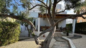 A building with a patio area, outdoor seating, and a gravel pathway. - VILLA BLANCA, large villa ideal for families in Cala Dór by Aixo Villas (Felanitx)