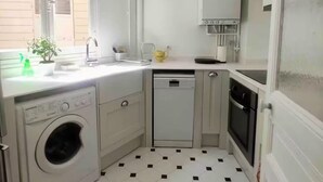 A compact kitchen with a washing machine, a dishwasher, and a stove. - Beaut. Hausmannian flat in Oberkampf near Marais (Paris)