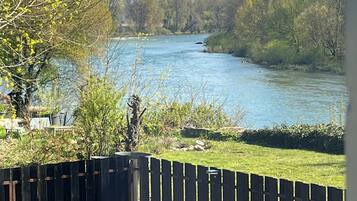 Un río con una cerca de madera al frente.
