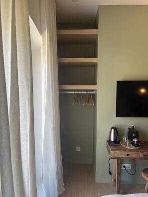 A room with a wooden desk, a flat-screen TV, a kettle, and a coffee maker. - Le Clos des Berges de l'Ain - House 8/10 pers with swimming pool on the river bank - France (Charnoz-sur-Ain)