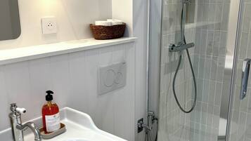 Ein modernes Badezimmer mit Waschbecken, Toilette und einer Duschkabine.