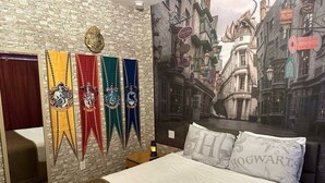 Et soveværelse med en stor seng, en stenvæg og et Harry Potter-inspireret vægmaleri.