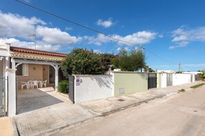 A residential building with a covered patio, a gated entrance, and a clear blue sky. - TTotti Coast House by BarbarHouse (Torre Specchia Ruggeri)