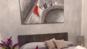 A modern bedroom with a bed, bedside table, and a potted plant. - Montereale Holiday House Apartment with Wi-Fi, Air Conditioning and Sauna on Request (Monreale)
