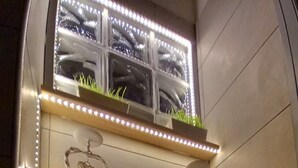 A bathroom with shelves holding towels and a window with plants. - Montereale Holiday House Apartment with Wi-Fi, Air Conditioning and Sauna on Request (Monreale)