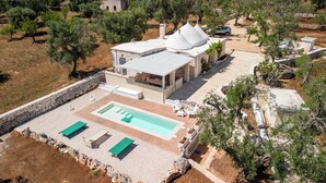 A villa with a swimming pool, outdoor seating, and a stone wall surrounding the property. - Trullo Cecapesce by Perle di Puglia (Carovigno)