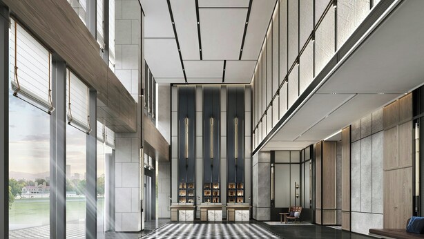Un hall d’entrée spacieux, doté d’un sol à carreaux, de grandes fenêtres et d’un espace de repos central avec un banc et une chaise.