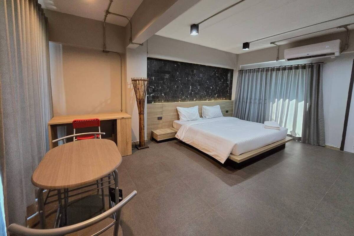 Quarto de hotel moderno com cama, escrivaninha e cadeira.