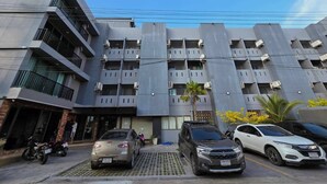 A multi-story residential building with balconies, parked cars, and a clear sky. - SSP Residence Bang Bua Thong (Bang Bua Thong)
