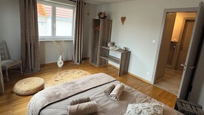 Un dormitorio con una cama grande, un armario, un escritorio y una ventana con cortinas.