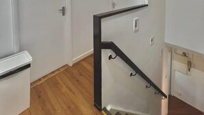 Ein modernes Interieur mit Treppe, weißen Wänden und Holzböden.
