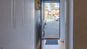 A hallway leading to a garage with a car parked outside. - M13 Manchester 2 Bed | Parking | 15% Discount (Manchester)