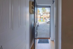 Ein Flur, der zu einer Garage führt, vor der ein Auto steht.