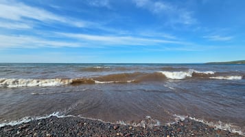 Ein Strand mit Kieselsteinen und Wellen.