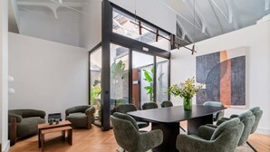 Uma sala de conferências moderna com uma mesa grande, cadeiras estofadas cinzas e um painel de vidro.