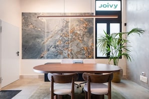 A conference room with a large abstract painting, a wooden table, and two chairs. - Pac Fico Deluxe Twins Suite Near Retiro (Madrid)