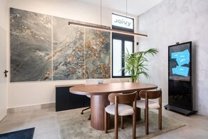 A modern conference room with a large marble wall, a round table, and four chairs. - Pac Fico Deluxe Twins Suite Near Retiro (Madrid)