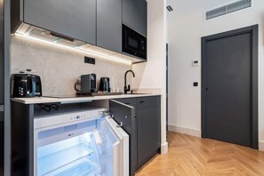 A compact kitchen with a built-in microwave, coffee maker, and refrigerator. - Pac Fico Deluxe Twins Suite Near Retiro (Madrid)