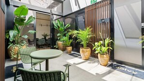 A modern indoor space with a seating area, potted plants, and a door marked with the number 09. - Pac Fico Suite With Double Sofa Bed Near Retiro (Madrid)