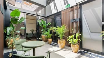 A modern indoor space with a seating area, potted plants, and a door marked with the number 09.