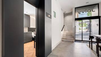 A modern interior with a kitchen, a staircase, and a dining area.