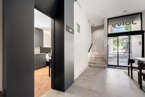 Un interior moderno con cocina, escalera y comedor.