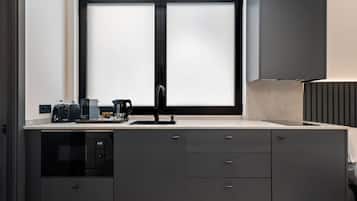 Una cocina moderna con un lavamanos doble, una cafetera y un microondas.