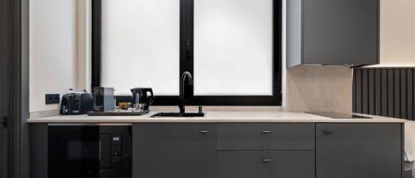 A modern kitchen with a double sink, a coffee maker, and a microwave.