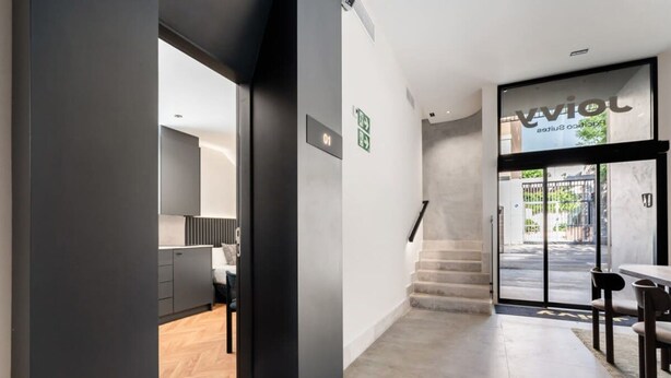 A modern interior with a kitchen, a staircase, and a dining area. - Pacifico Accessible Suite Near Retiro (Madrid)