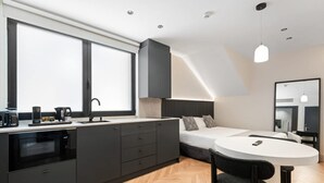 A modern bedroom with a bed, bedside table, and a large window. - Pacifico Accessible Suite Near Retiro (Madrid)